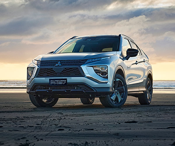 Grey SUV on a beach at sunset