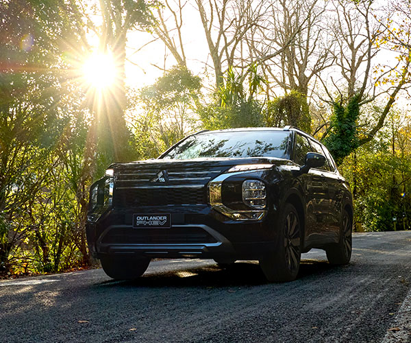A black SUV driving on a forest road